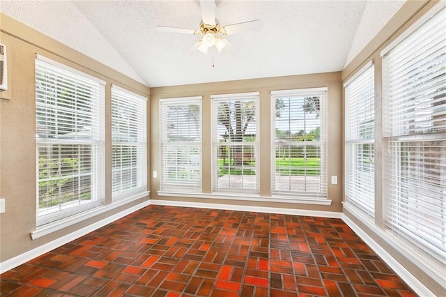 unfurnished sunroom with baseboards, brick floor, vaulted ceiling, and a wealth of natural light