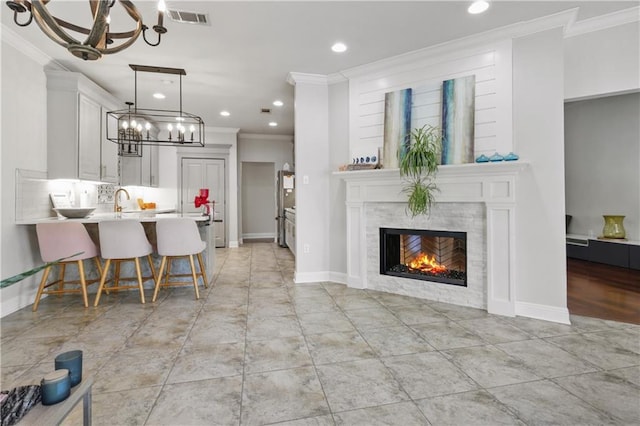 413 Dockside Dr, Slidell, LA 70461 - interior space featuring visible vents, a tiled fireplace, an inviting chandelier, ornamental molding, and recessed lighting