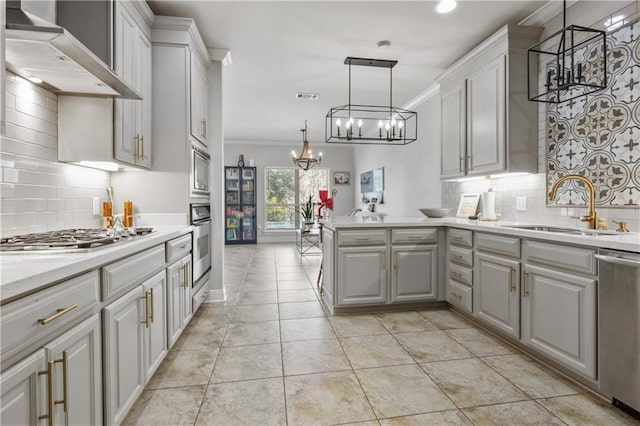 413 Dockside Dr, Slidell, LA 70461 - kitchen featuring appliances with stainless steel finishes, an inviting chandelier, a sink, light countertops, and wall chimney exhaust hood
