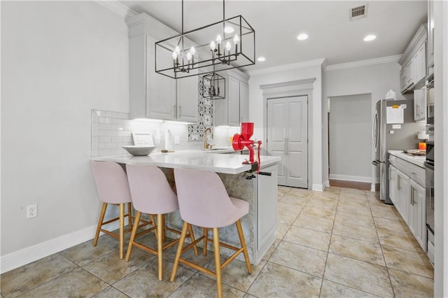413 Dockside Dr, Slidell, LA 70461 - kitchen with visible vents, tasteful backsplash, light countertops, a peninsula, and ornamental molding