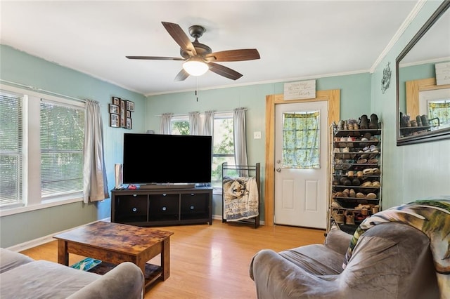 living room with crown molding, ceiling fan, and wood finished floors