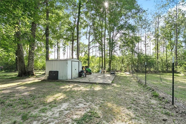 view of yard featuring fence, an outbuilding, and a storage unit