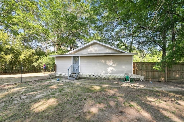 view of outdoor structure with fence and entry steps