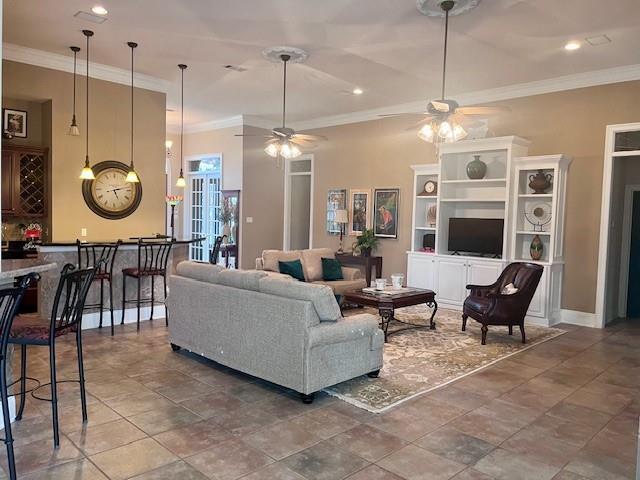 living room with baseboards, ceiling fan, ornamental molding, and recessed lighting
