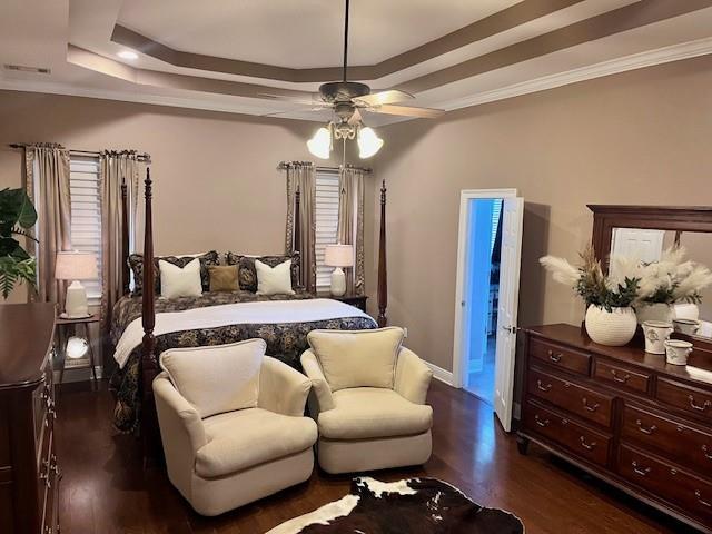 bedroom with baseboards, a ceiling fan, a tray ceiling, and dark wood-style floors