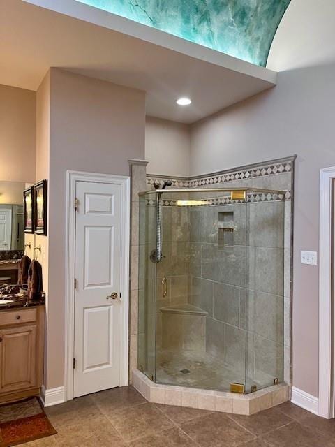 bathroom featuring vanity, tile patterned floors, baseboards, and a shower stall