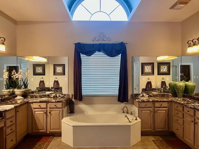 full bath featuring visible vents, tile patterned flooring, a bath, and a wealth of natural light