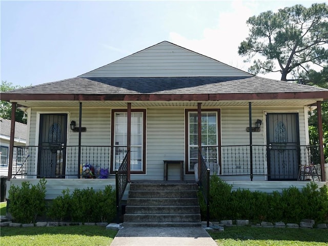 view of front of house featuring a shingled roof and covered porch