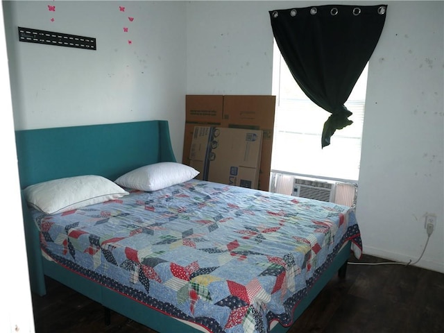 bedroom featuring baseboards, wood finished floors, and cooling unit
