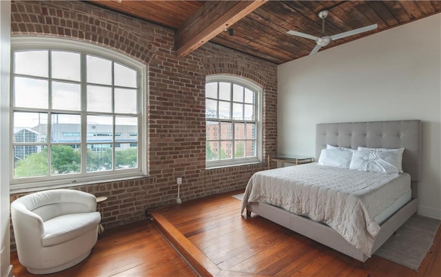 bedroom with wood ceiling, beam ceiling, brick wall, and hardwood / wood-style floors