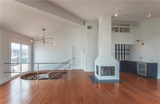 interior space featuring beverage cooler, hardwood / wood-style flooring, a chandelier, and visible vents