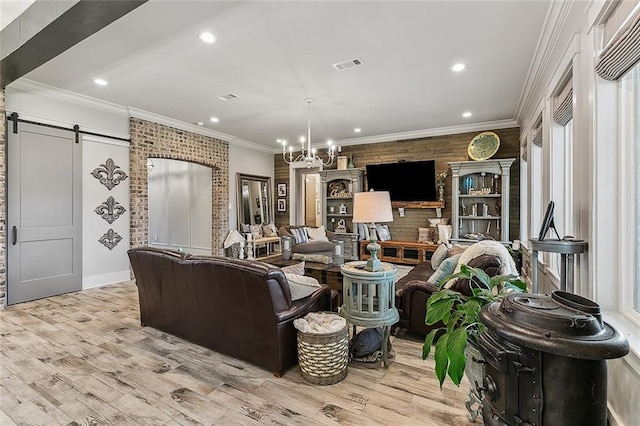 living room with recessed lighting, visible vents, a barn door, and light wood-type flooring