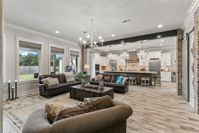 living area with visible vents, crown molding, a notable chandelier, recessed lighting, and light wood-style flooring