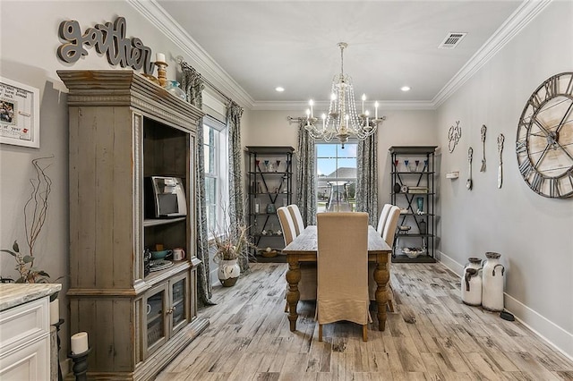 dining area with crown molding, baseboards, a notable chandelier, and light wood-type flooring