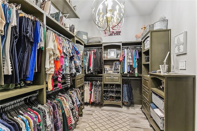 spacious closet featuring a chandelier and wood finished floors