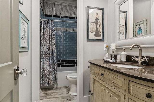 full bath with toilet, wood finished floors, shower / bath combo, and vanity