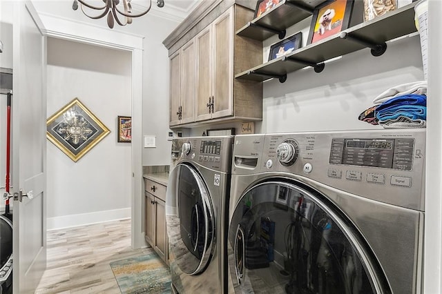 washroom with light wood-type flooring, cabinet space, baseboards, an inviting chandelier, and washer and dryer