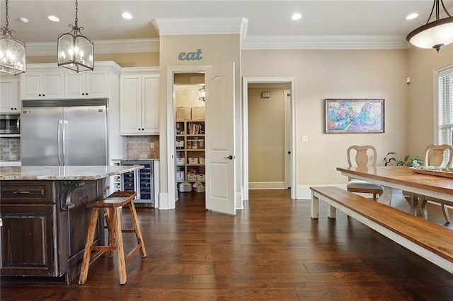kitchen featuring white cabinets, built in appliances, beverage cooler, dark wood finished floors, and decorative backsplash