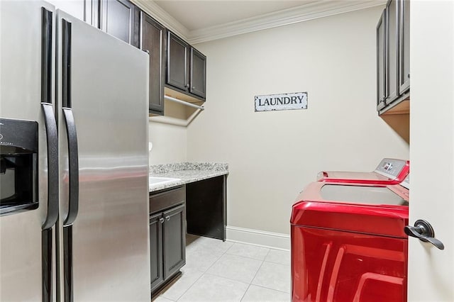 laundry area with washer and dryer, cabinet space, baseboards, light tile patterned floors, and ornamental molding