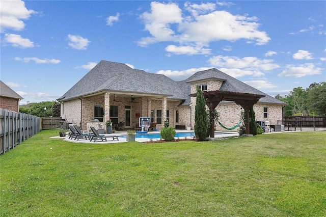 back of property featuring a fenced backyard, a ceiling fan, a patio, and a yard