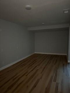 basement with baseboards and wood finished floors