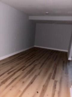 below grade area featuring baseboards and wood finished floors