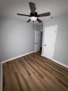 unfurnished bedroom featuring baseboards, ceiling fan, wood finished floors, and a closet