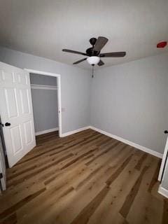 unfurnished bedroom featuring a ceiling fan, baseboards, wood finished floors, and a closet