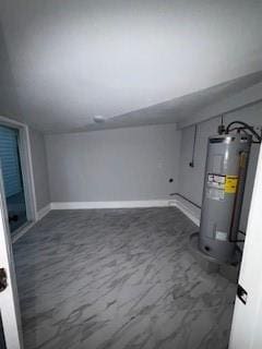 basement with baseboards and water heater