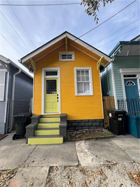 view of front facade with entry steps and fence