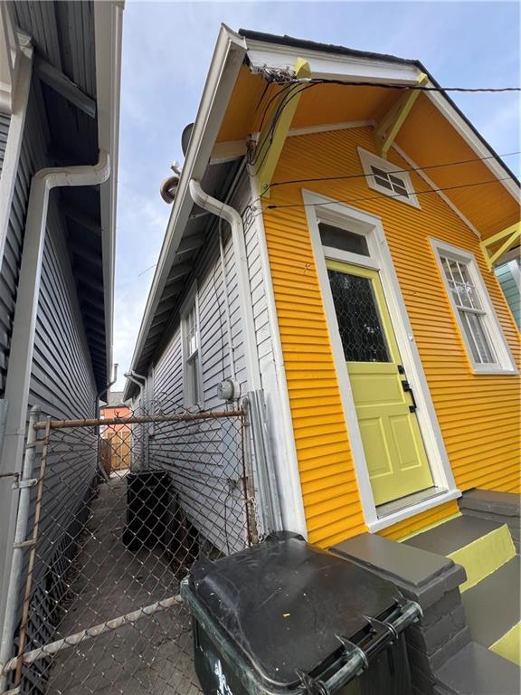view of side of home featuring fence, a gate, and entry steps