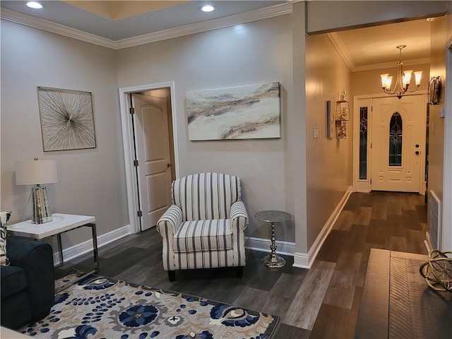 corridor featuring baseboards, ornamental molding, wood finished floors, and a notable chandelier