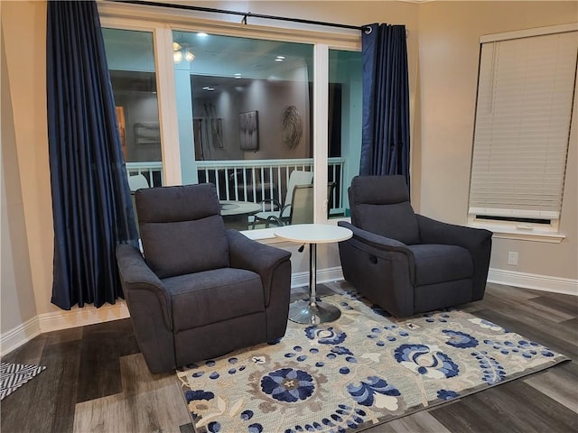 living area with baseboards and wood finished floors