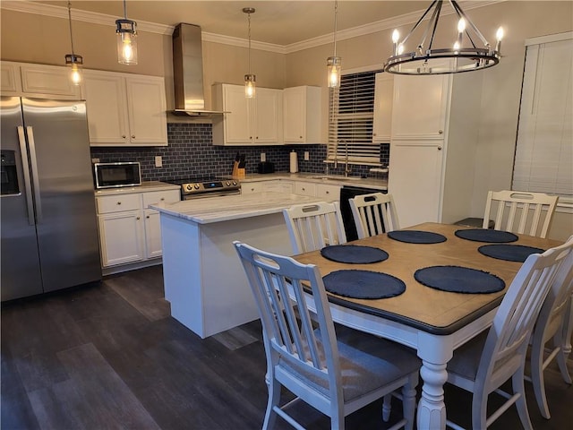 kitchen with appliances with stainless steel finishes, wall chimney exhaust hood, white cabinetry, dark wood-type flooring, and backsplash