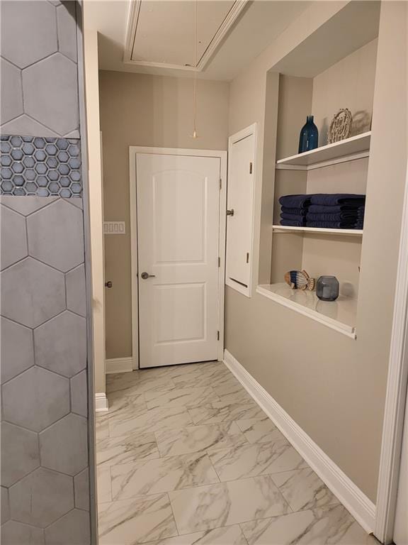 doorway with baseboards and marble finish floor