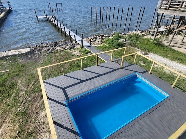 view of swimming pool with a boat dock and a water view