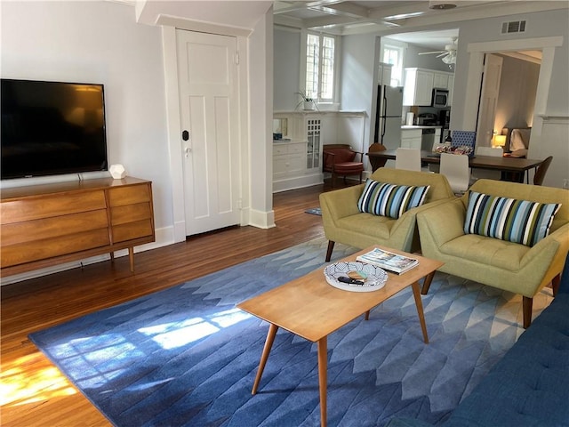 living area featuring ceiling fan, visible vents, and wood finished floors