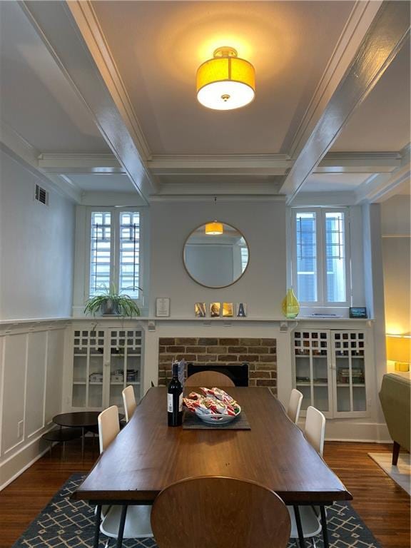 dining space featuring beam ceiling, wood finished floors, and coffered ceiling