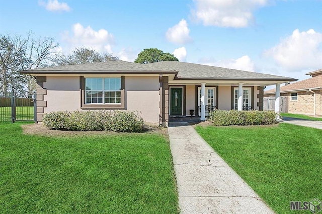 view of front of property featuring stucco siding, a front lawn, fence, and covered porch