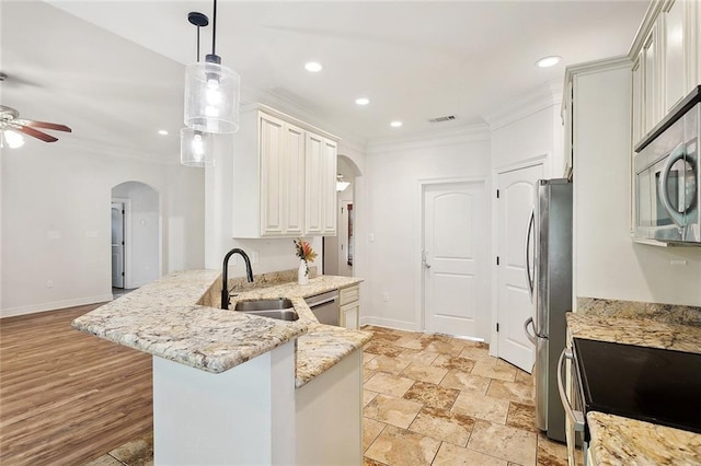 61267 Forest Dr, Lacombe, LA 70445 - kitchen with ornamental molding, a sink, ceiling fan, arched walkways, and appliances with stainless steel finishes