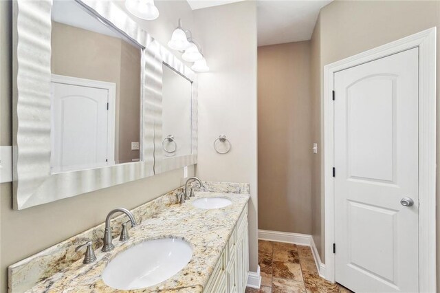61267 Forest Dr, Lacombe, LA 70445 - full bathroom featuring double vanity, baseboards, stone finish flooring, and a sink
