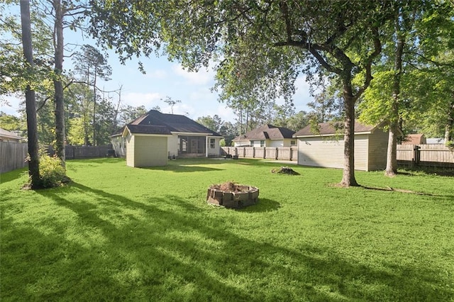 61267 Forest Dr, Lacombe, LA 70445 - view of yard featuring an outbuilding, a fire pit, and a fenced backyard