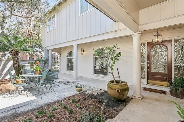 4524 Folse Dr, Metairie, LA 70006 - view of exterior entry featuring board and batten siding, a patio area, and brick siding