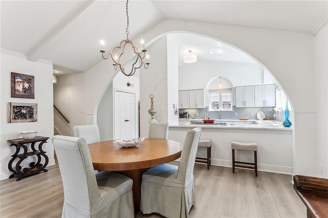 4524 Folse Dr, Metairie, LA 70006 - dining area with arched walkways, a notable chandelier, light wood-style flooring, and lofted ceiling