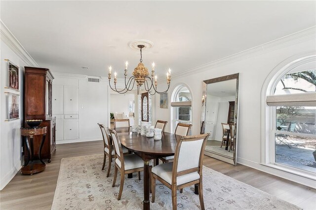 4524 Folse Dr, Metairie, LA 70006 - dining area with ornamental molding, a notable chandelier, light wood-style flooring, and visible vents