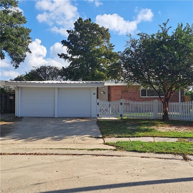 24 Caribou Ct, Metairie, LA 70003 - ranch-style home featuring a fenced front yard, a detached garage, and metal roof