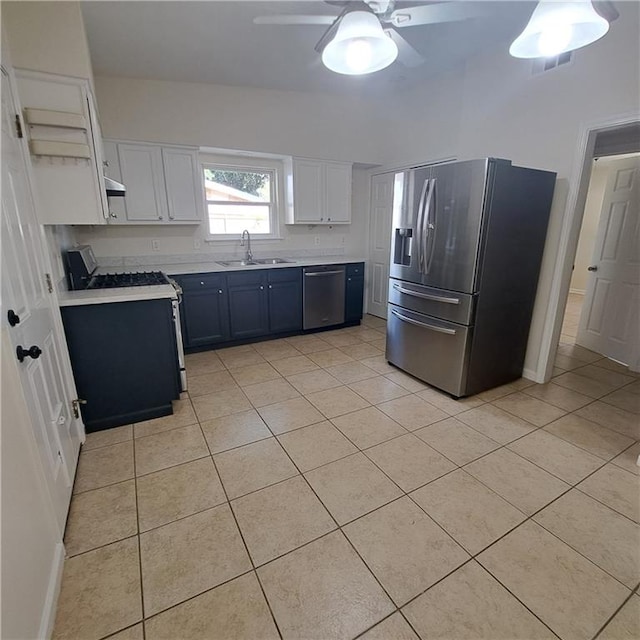 24 Caribou Ct, Metairie, LA 70003 - kitchen featuring appliances with stainless steel finishes, a sink, light tile patterned floors, light countertops, and white cabinetry