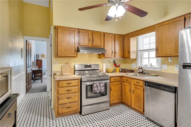 kitchen featuring ceiling fan, light countertops, under cabinet range hood, a sink, and stainless steel appliances