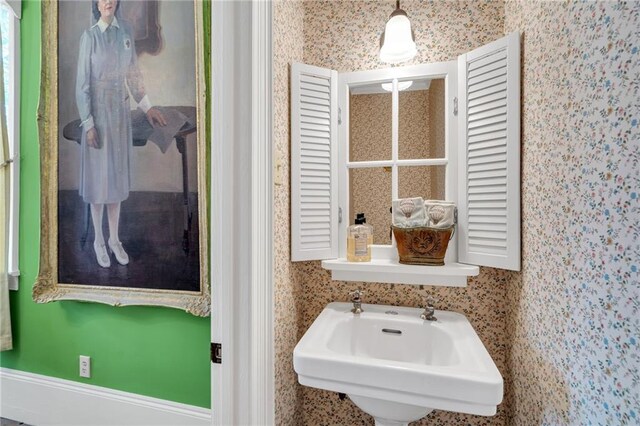 bathroom with a sink and wallpapered walls