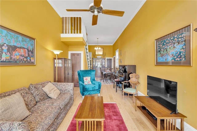 living area with ornamental molding, a ceiling fan, and wood finished floors